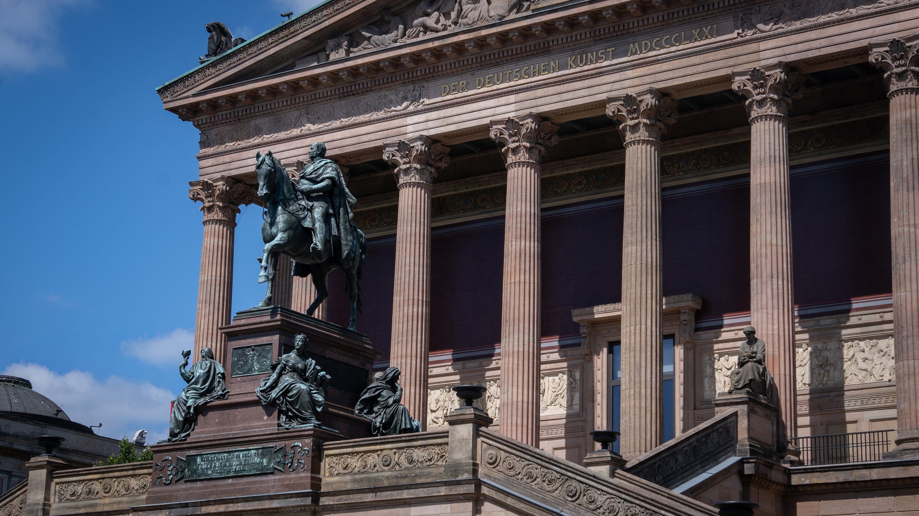 The columned facade of a museum with an equestrian statue
