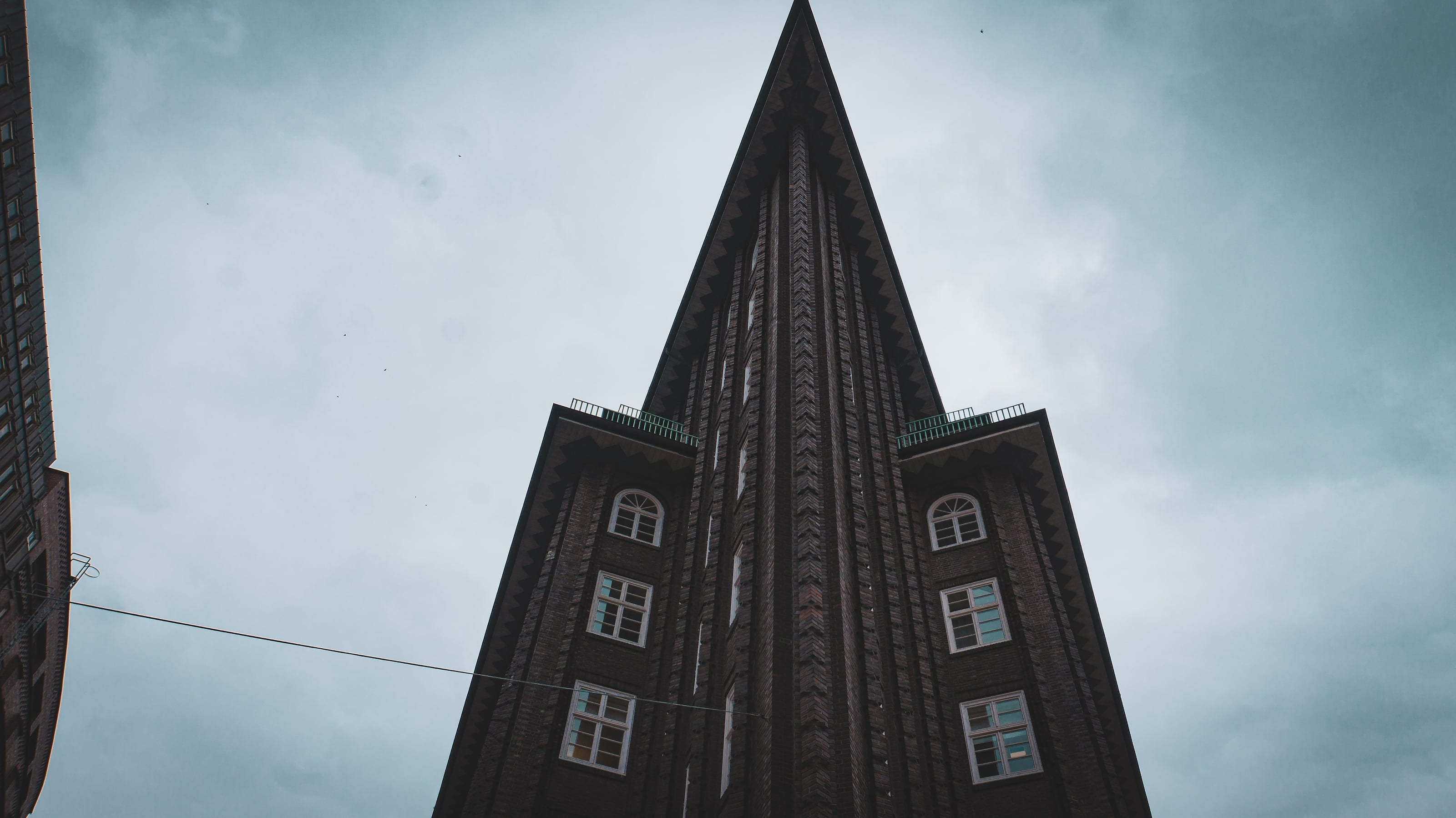 A brick tower rising into an overcast sky