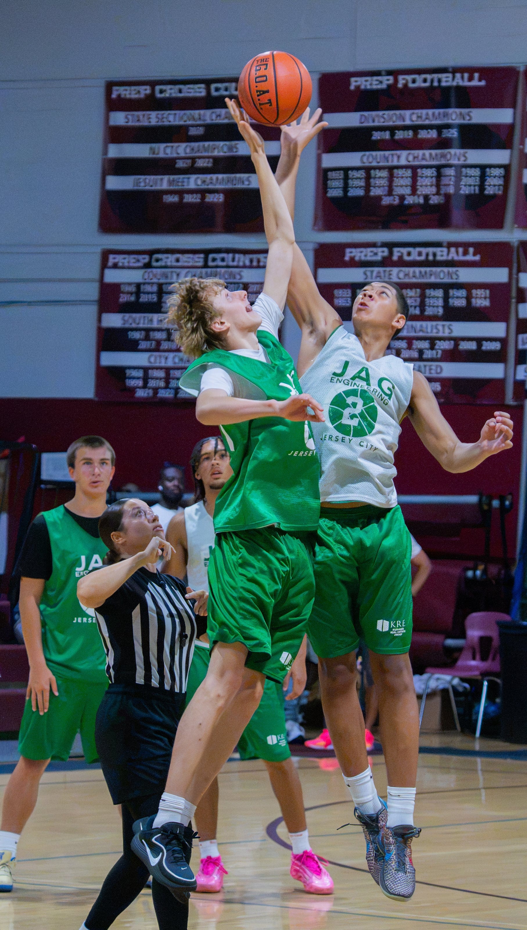 Two bodies up for the same ball beneath the banners