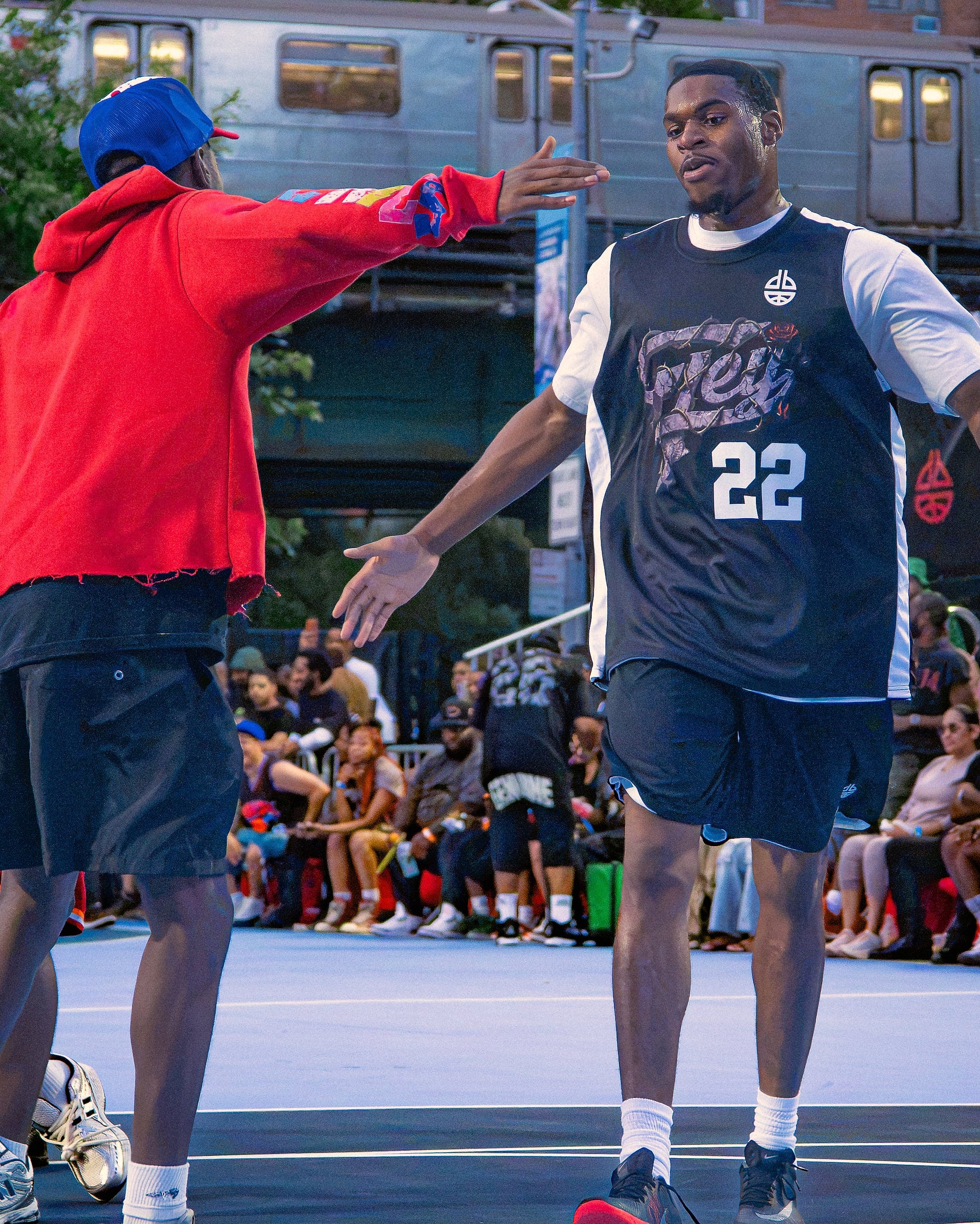 A handshake at the baseline, the 1 train pulling in behind