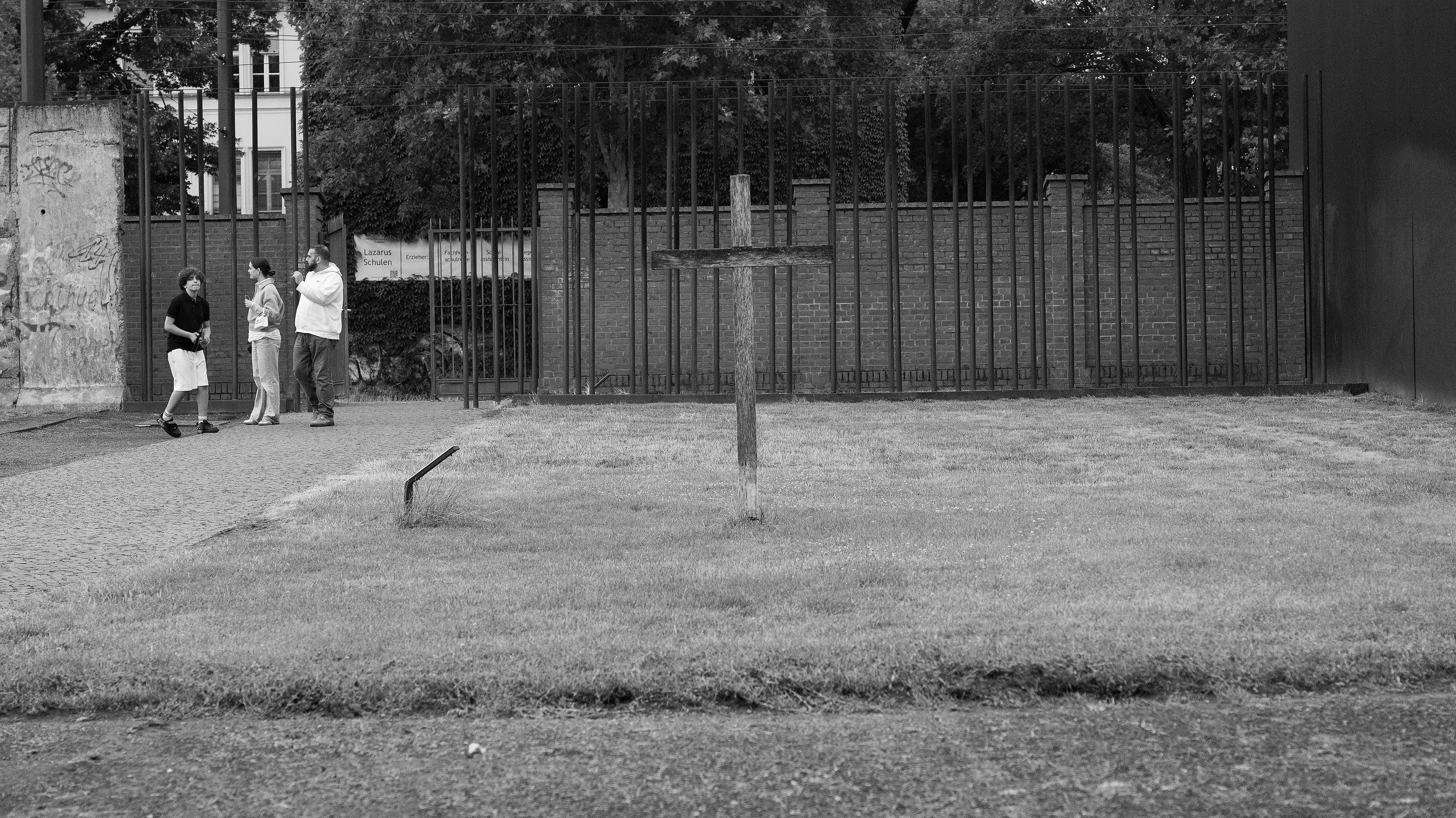 A weathered memorial cross on open ground